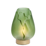 Green glass lamp with leaf patterns on a white background