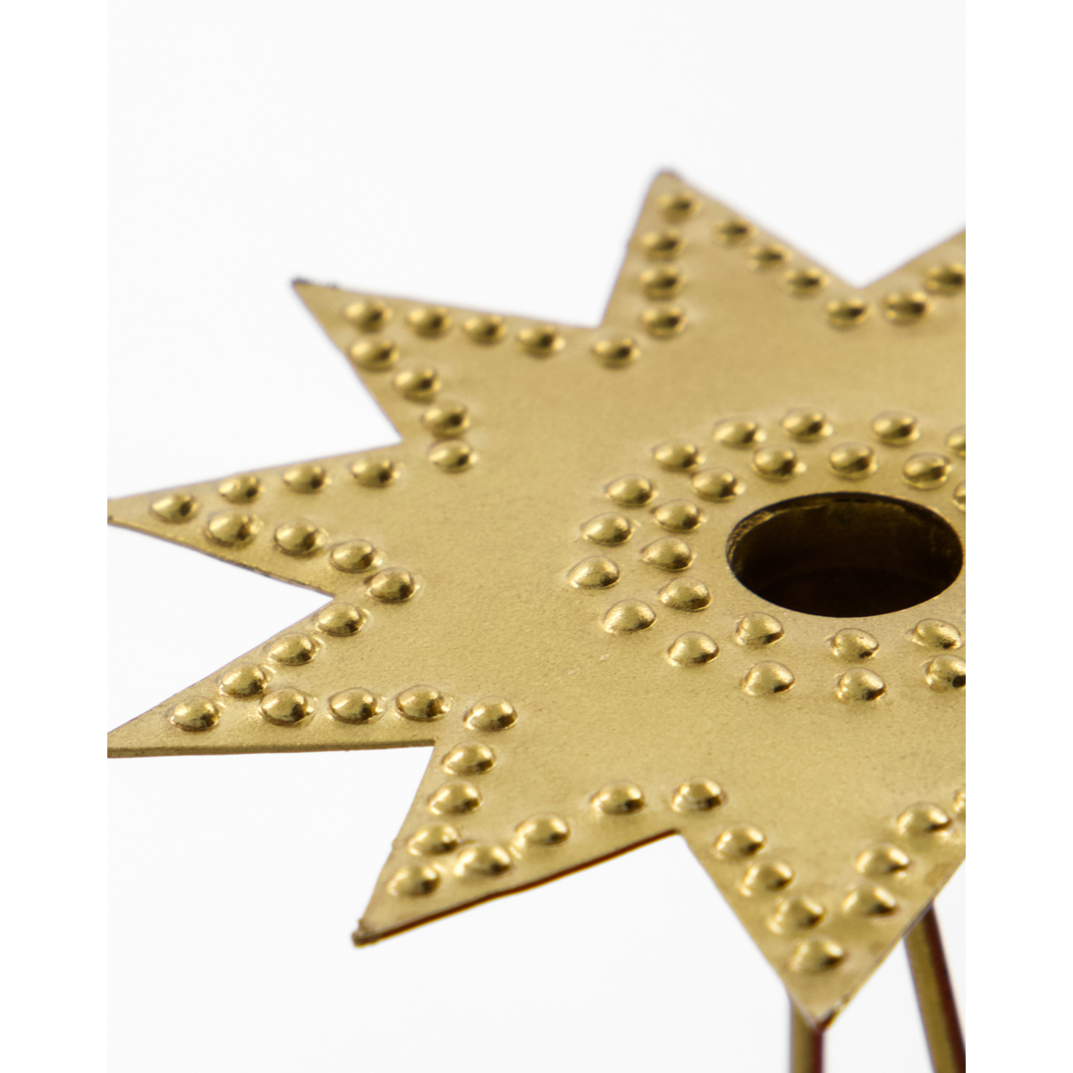 Gold star-shaped candle holder with textured surface on a white background