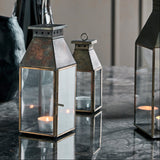 Decorative lanterns with candles on a reflective surface