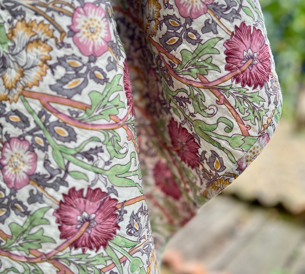 Close-up of a floral patterned fabric with pink and green colors.