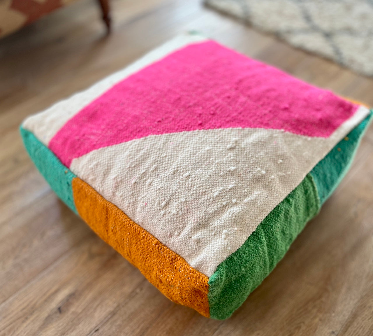 Colorful floor cushion with geometric pattern on a wooden floor