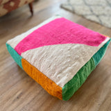 Colorful floor cushion with geometric pattern on a wooden floor