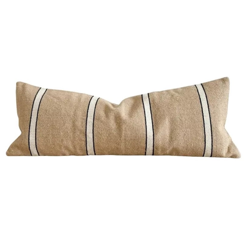 Beige pillow with white stripes on a white background