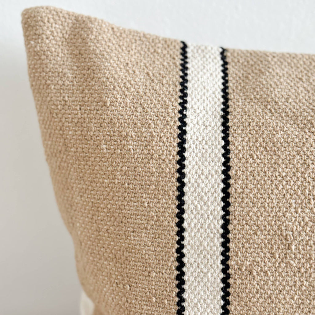 Textured pillow with a black and white stripe on a neutral background