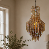 Dining room with wooden table, chairs, and decorative chandelier.