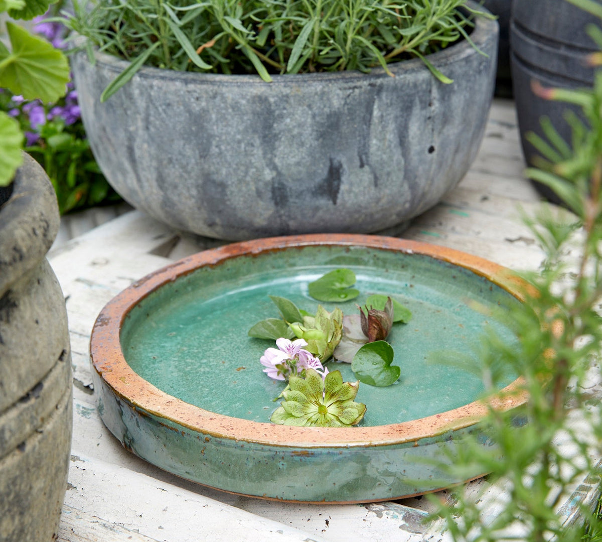 Jade green birdbath in outdoor setting