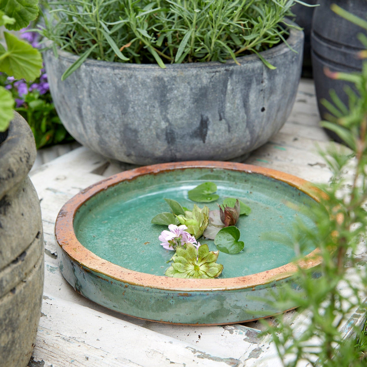 Jade green birdbath in outdoor setting
