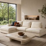 Modern living room with a beige sectional sofa, coffee table, and decorative items.