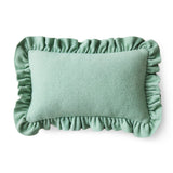 Green cushion with ruffled edges on a white background