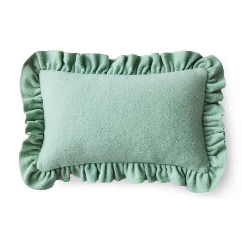 Green cushion with ruffled edges on a white background