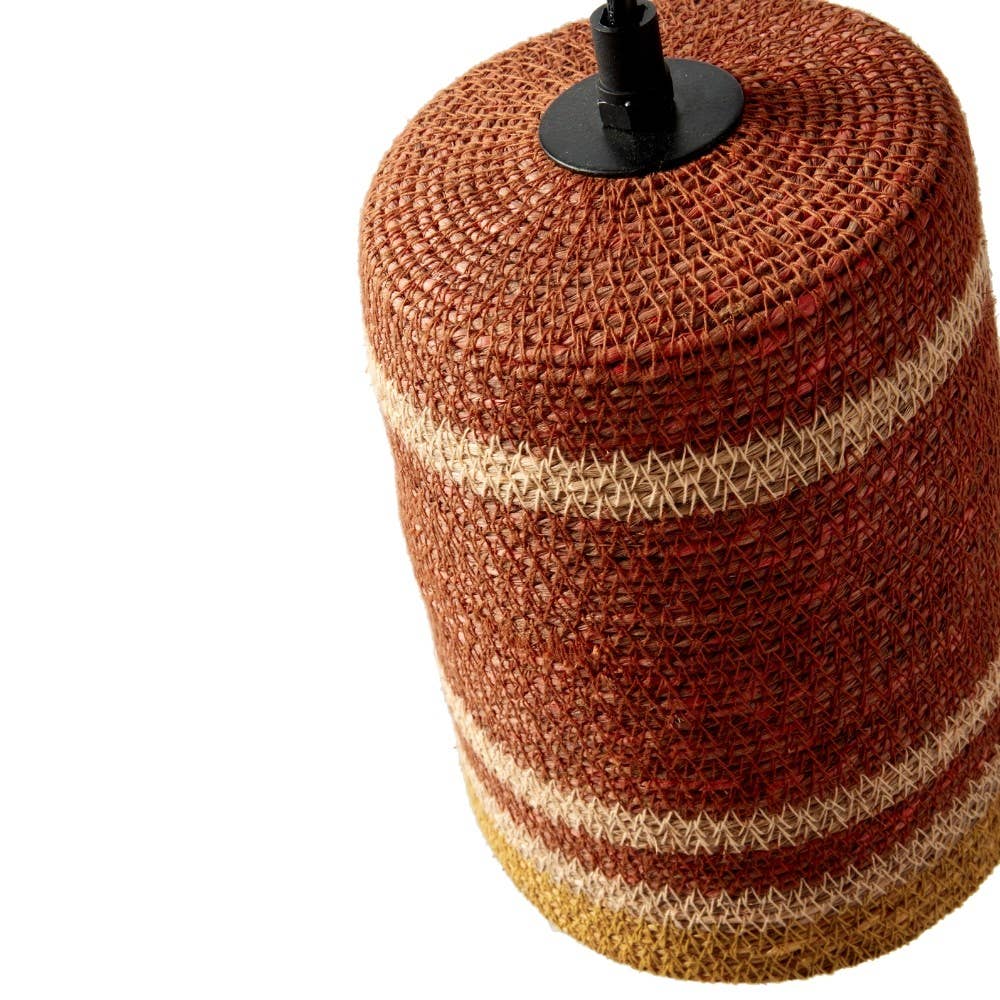 A woven cylindrical lampshade or decorative pot cover in a rust red and beige striped pattern, shown on a white background with a black top finial visible.