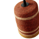 A woven cylindrical lampshade or decorative pot cover in a rust red and beige striped pattern, shown on a white background with a black top finial visible.