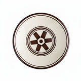 Ceramic plate with brown rim and decorative center on a white background