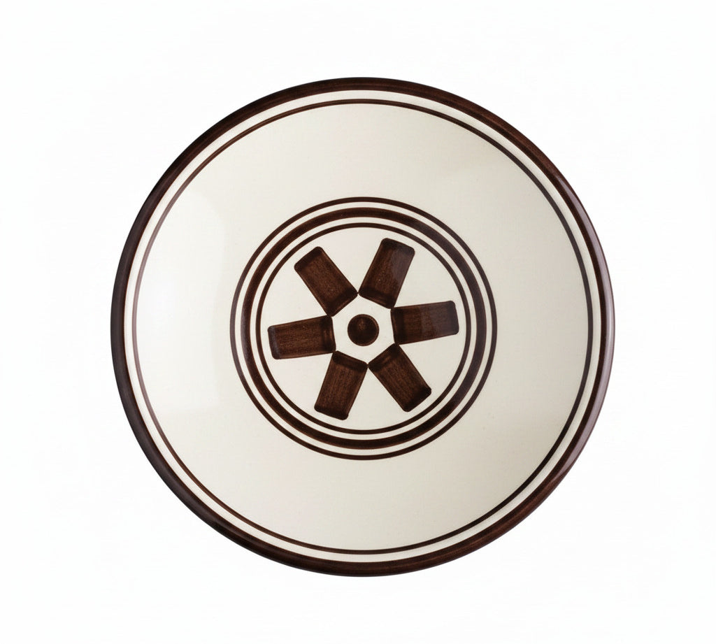Ceramic plate with brown rim and decorative center on a white background