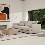 Modern living room with a gray sofa, coffee table, and abstract art on the wall.