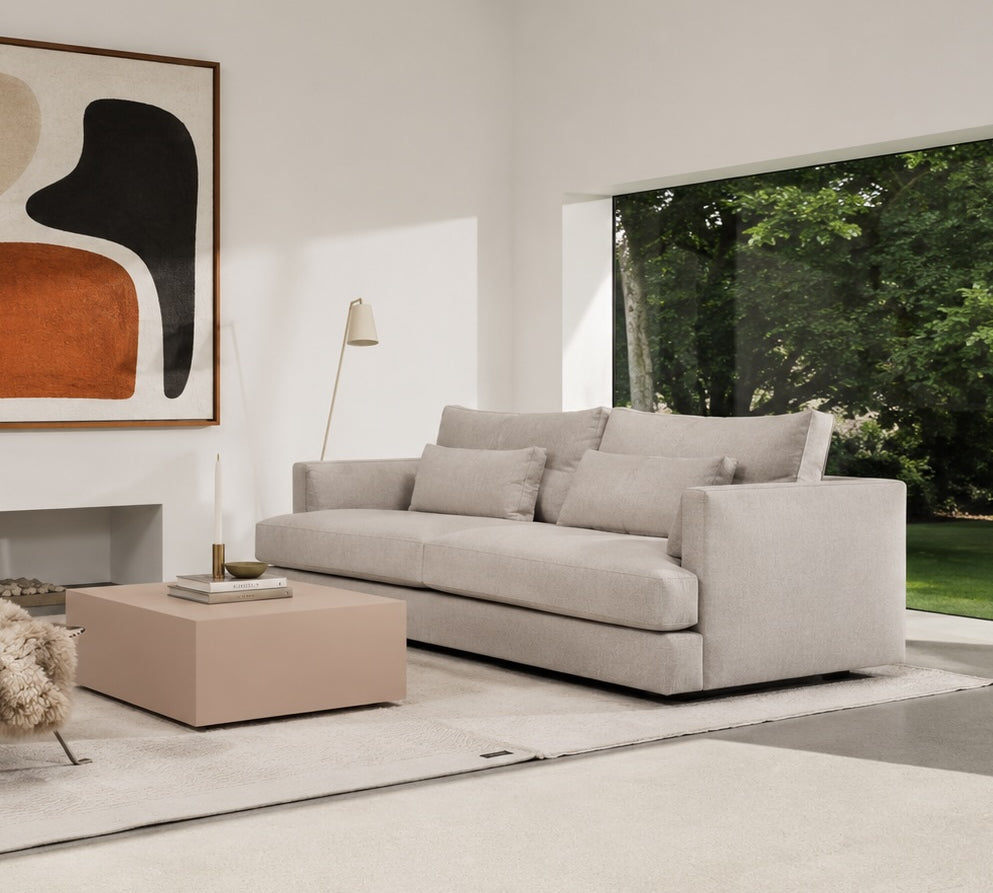 Modern living room with a gray sofa, coffee table, and abstract art on the wall.