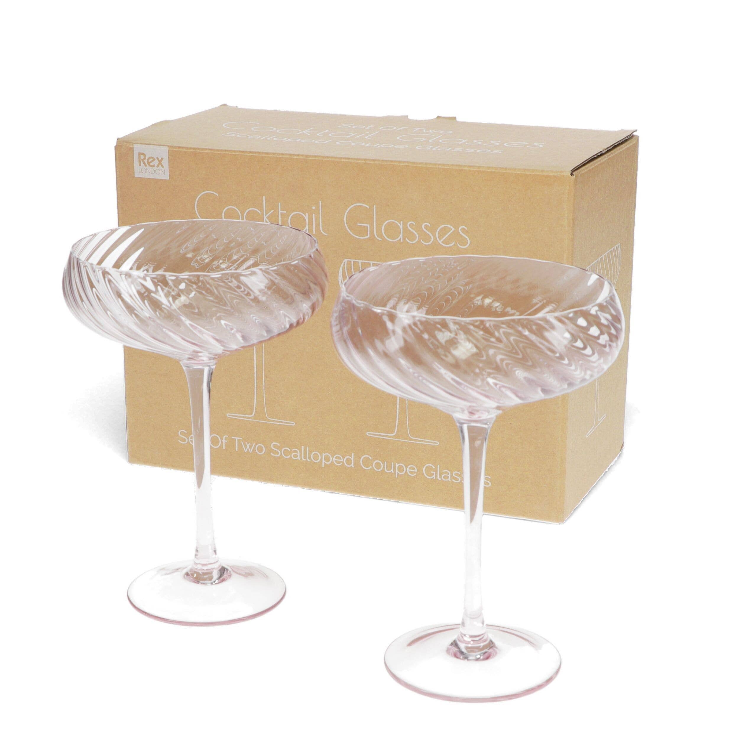 Two cocktail glasses in front of a cardboard box labeled 'Cocktail Glasses' on a white background.