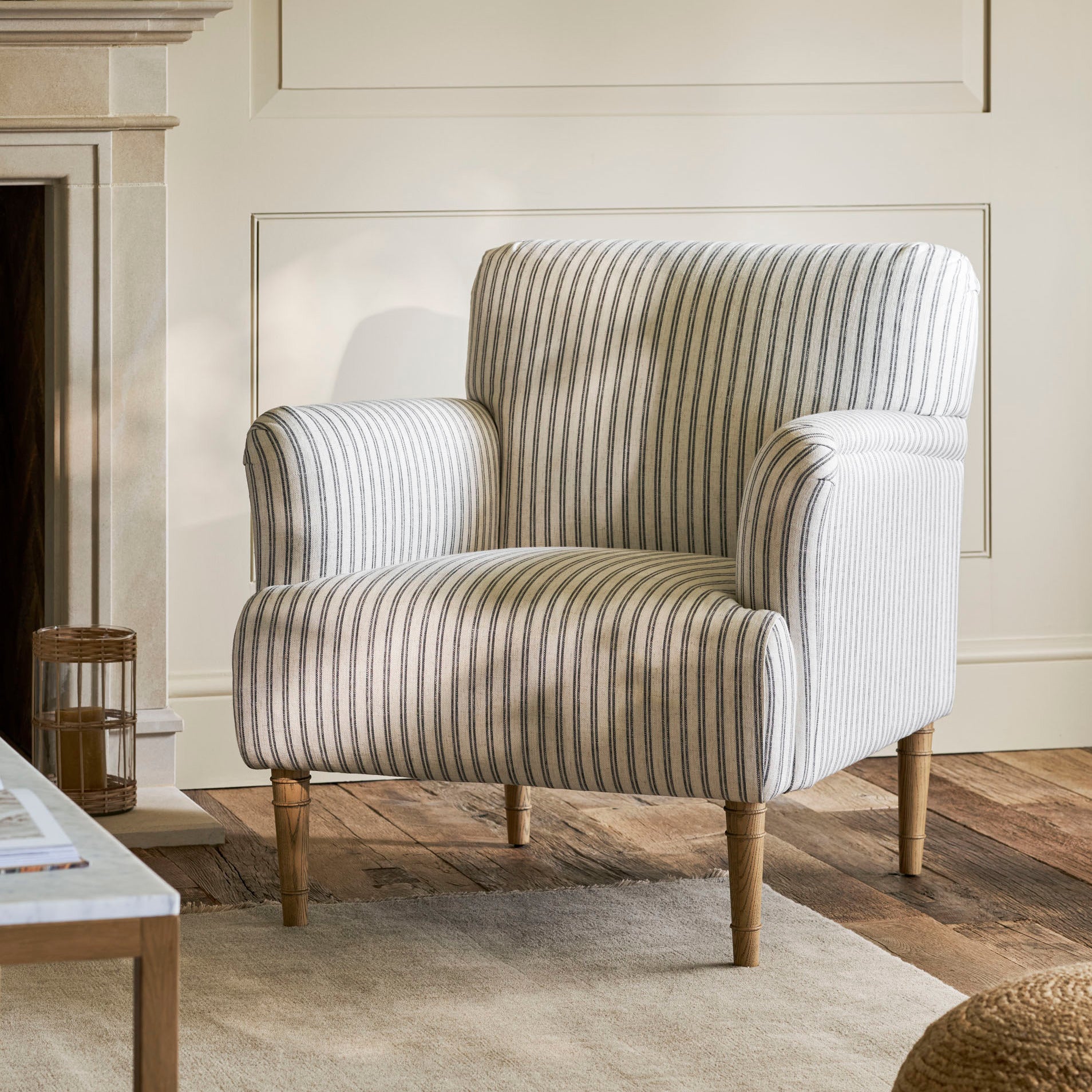 Striped armchair in a living room setting with wooden floor and fireplace.