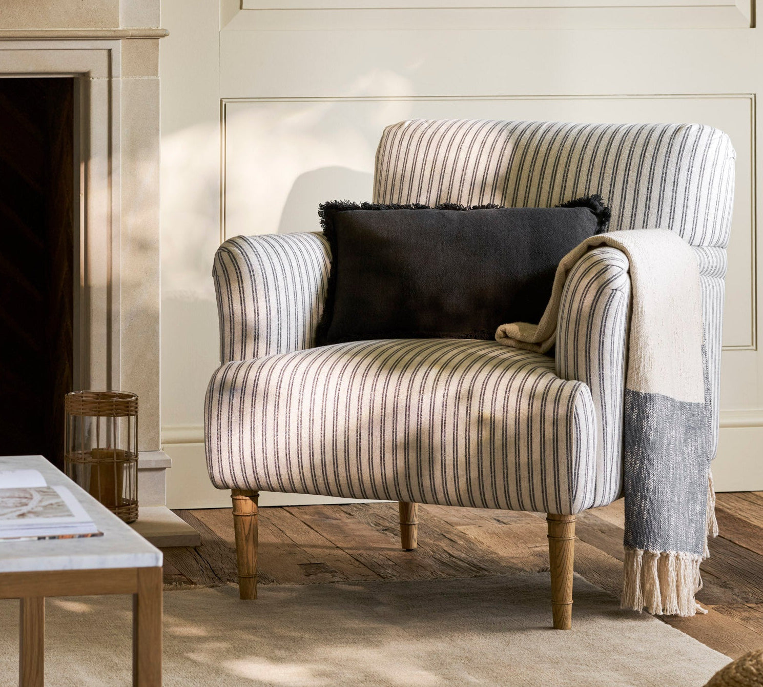 Striped armchair with a black pillow in a cozy living room setting.