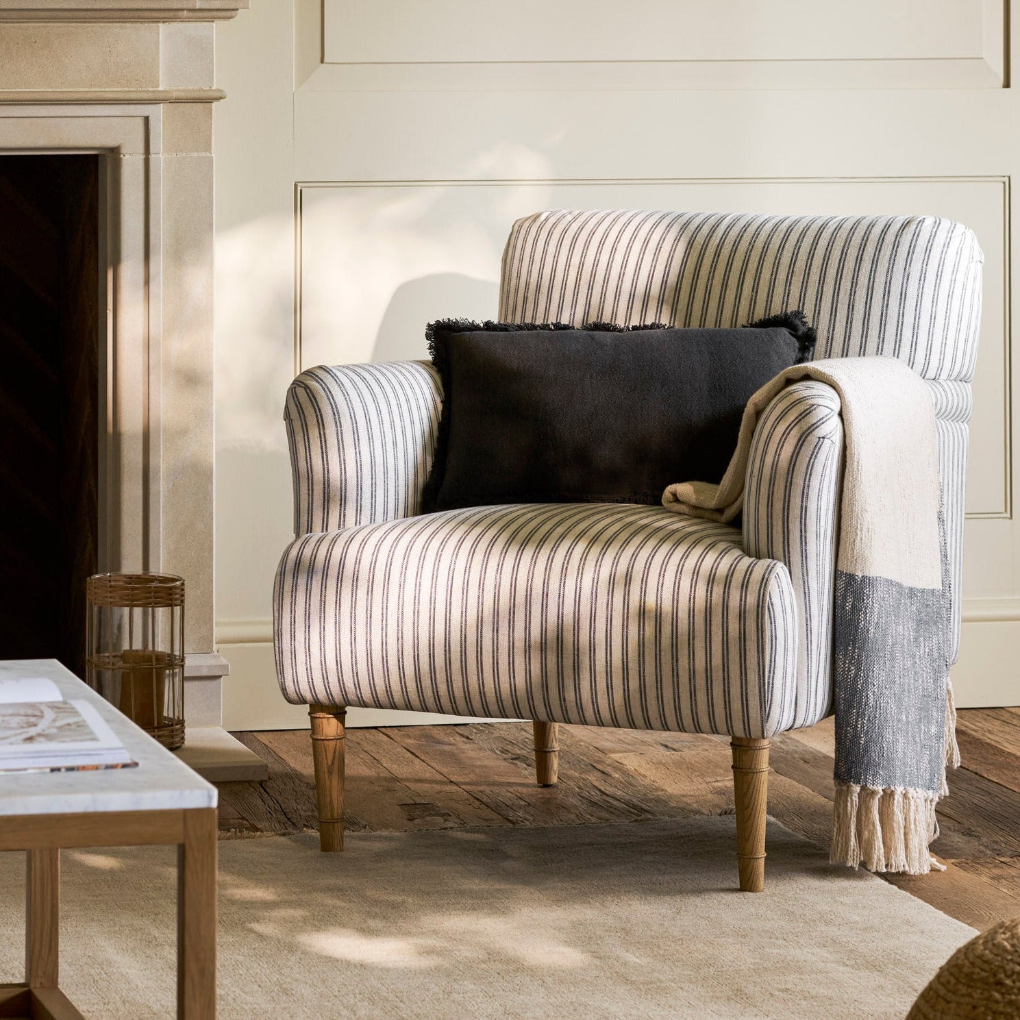 Striped armchair with a black pillow in a cozy living room setting.
