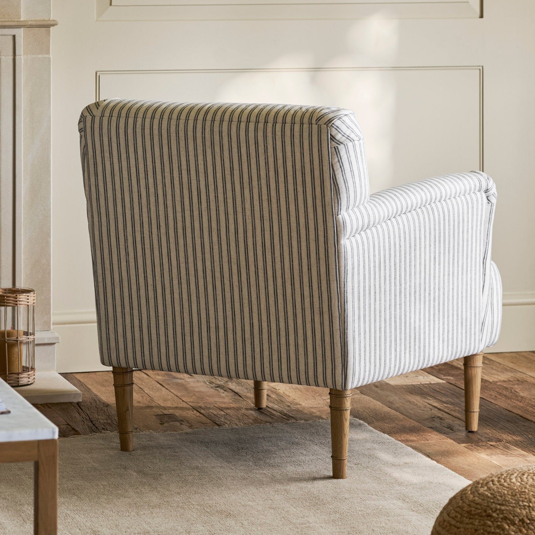 Striped armchair in a living room setting with a fireplace and wooden floor.
