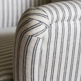 Close-up of a striped fabric armchair with a neutral color palette.