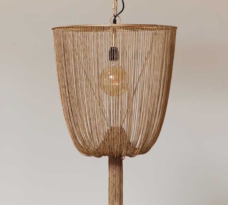 Gold beaded pendant light against a neutral background