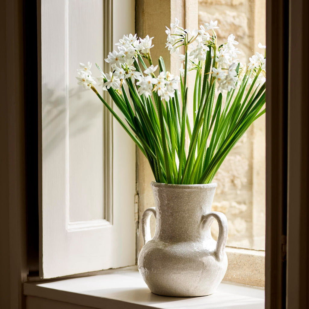 White flowers in a vase on a windowsill