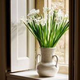 White flowers in a vase on a windowsill