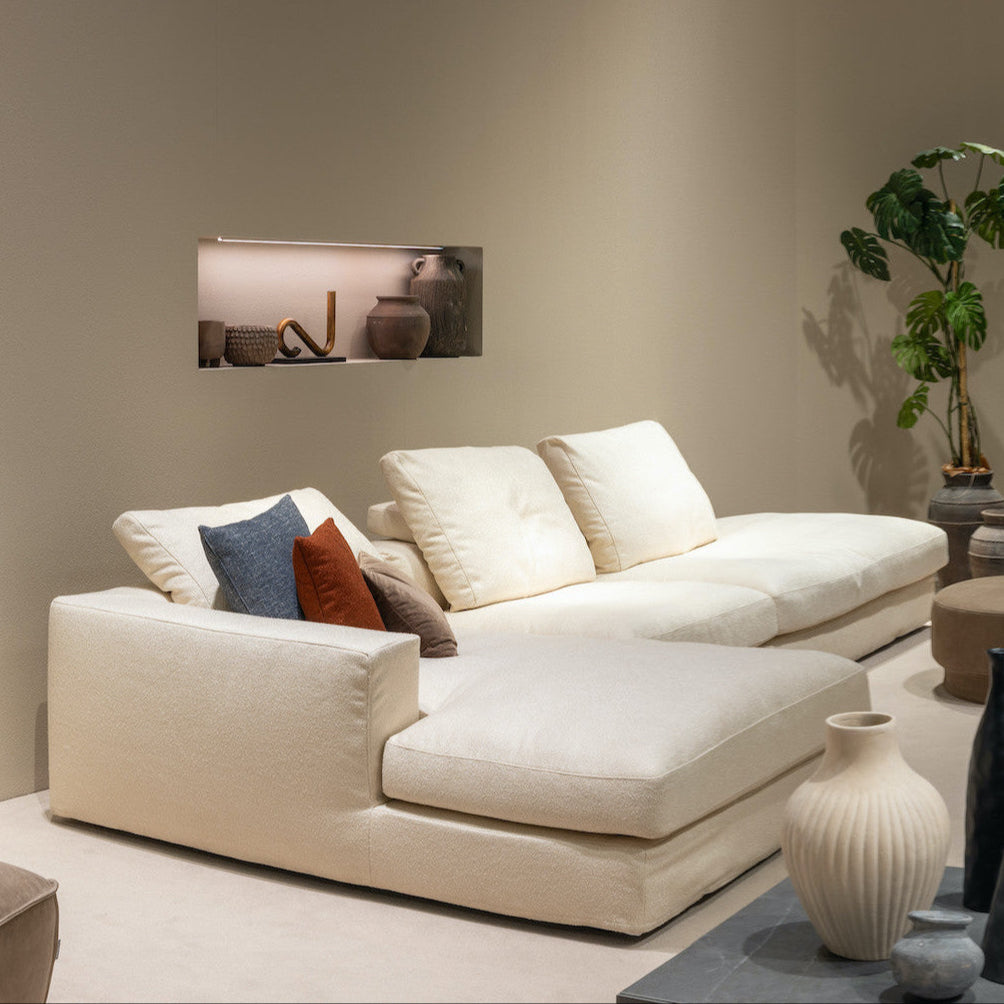 Beige sectional sofa with decorative pillows in a living room setting.