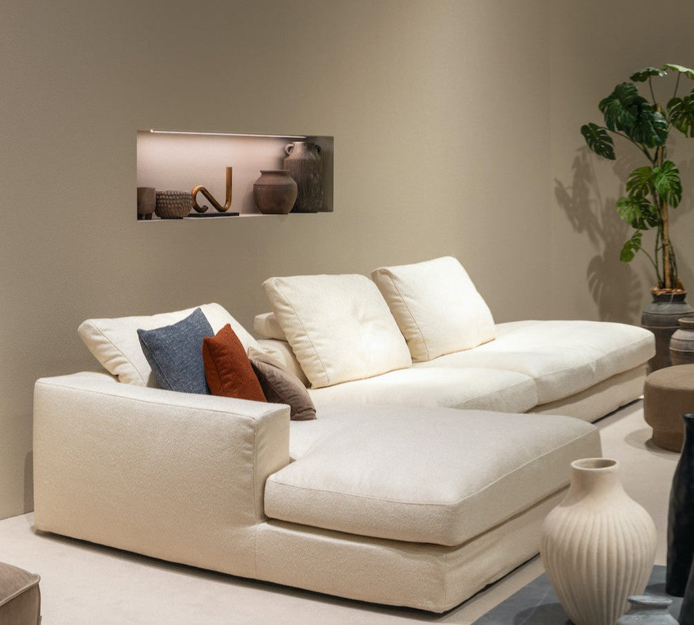 Beige sectional sofa with decorative pillows in a living room setting.