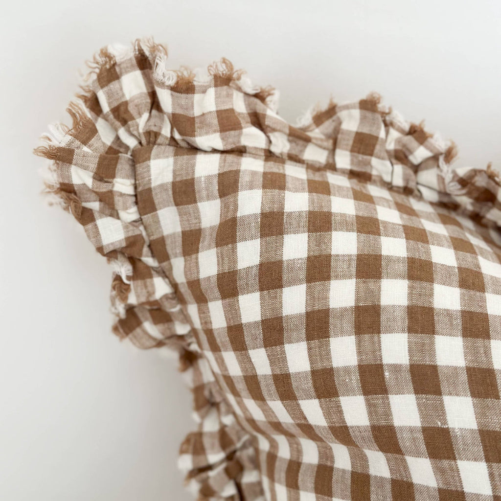 Brown and white checkered fabric with ruffled edges on a light gray background