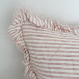 Close-up of a pink and white striped fabric with ruffled edge on a light background