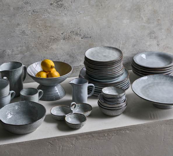Set of grey ceramic crockery on a concrete surface 