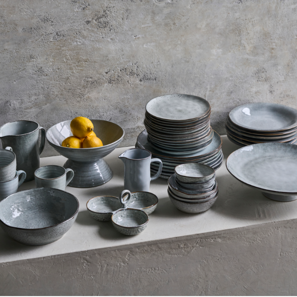 Set of grey ceramic crockery on a concrete surface 