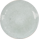 A round ceramic plate with a glossy off-white glaze and scattered dark speckles, shown from a top-down perspective on a white background.