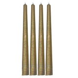 Four gold ribbed candles on a white background