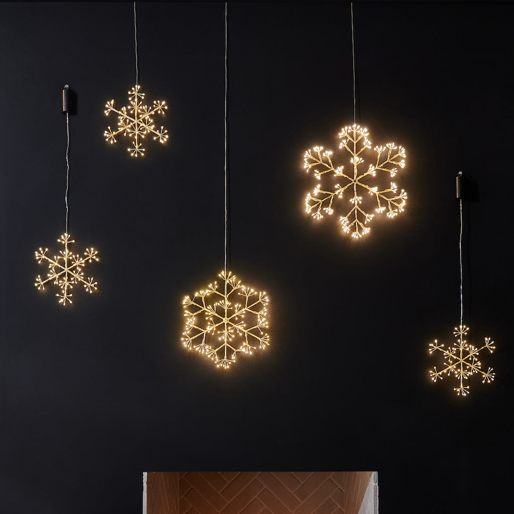 Decorative LED snowflake lights hanging against a dark background