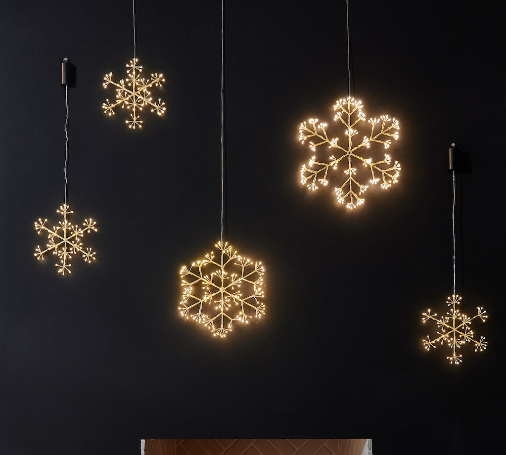 Decorative LED snowflake lights hanging against a dark background
