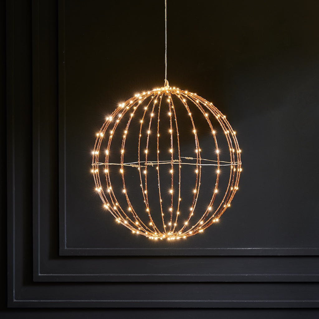 Decorative light fixture shaped like a sphere with string lights on a dark background
