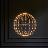 Decorative light fixture shaped like a sphere with string lights on a dark background