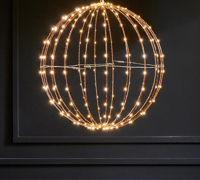Decorative light fixture shaped like a sphere with string lights on a dark background