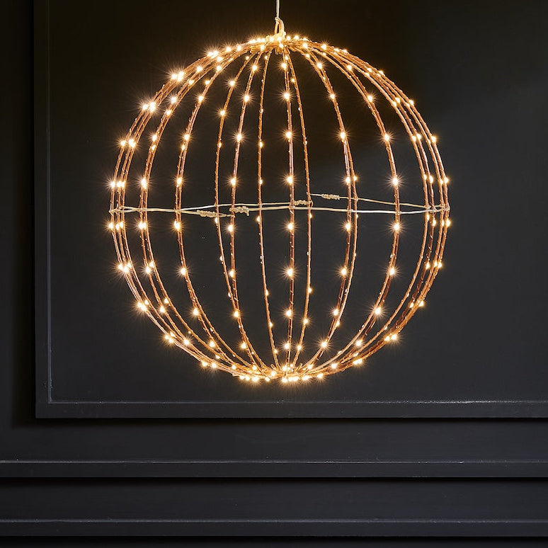 Decorative light fixture shaped like a sphere with string lights on a dark background