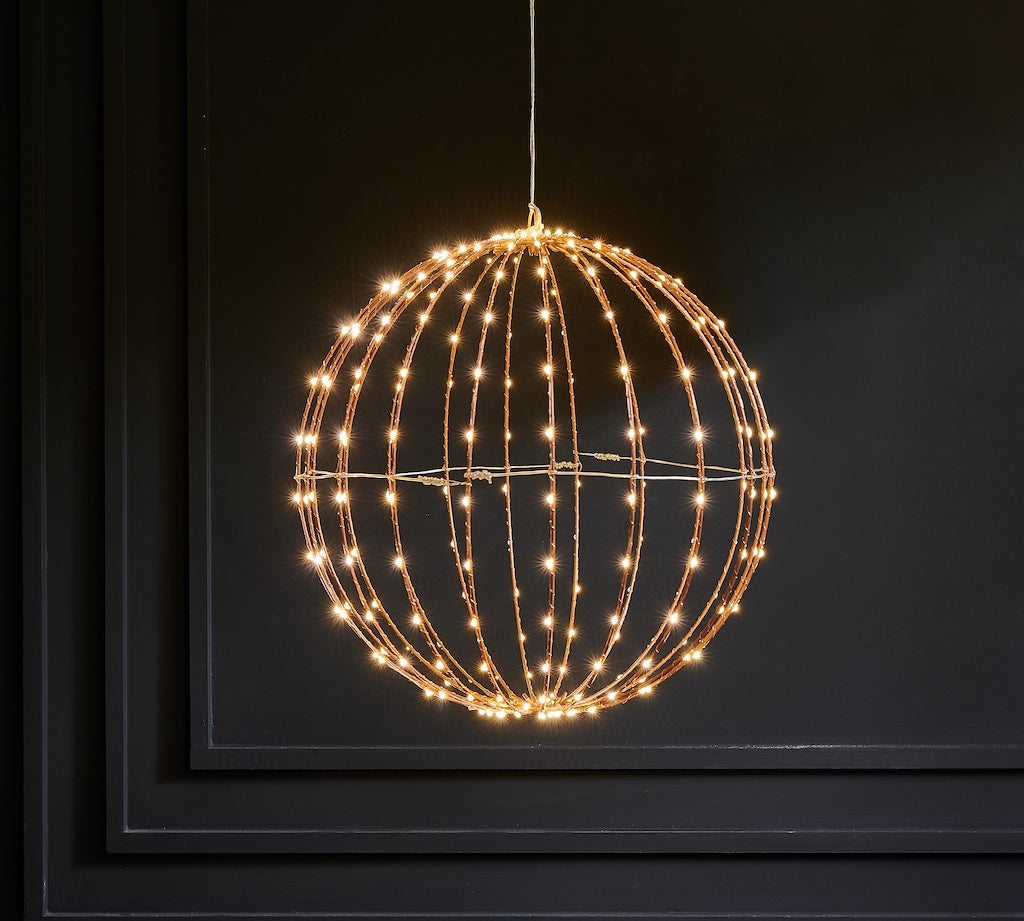 Decorative light fixture shaped like a sphere with string lights on a dark background