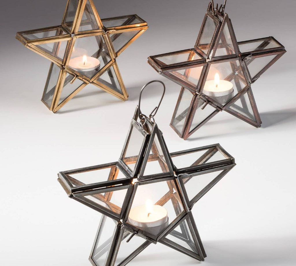 Star-shaped candle holders in gold, silver, and bronze on a gray background