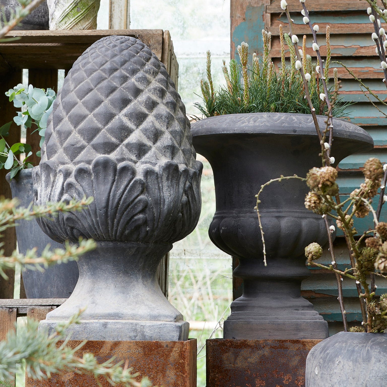 Decorative stone finial with intricate designs in a garden setting