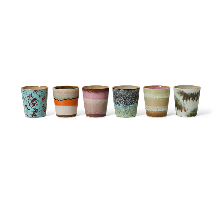 Set of six ceramic cups with multicolored glaze patterns on a white background