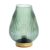 Green glass table lamp with ribbed design and gold base on a white background