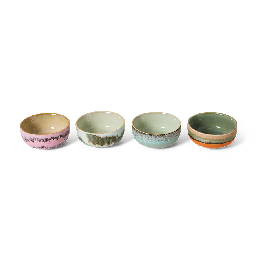 Four ceramic bowls with different color patterns on a white background