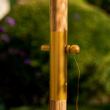 Wooden and brass pole with a blurred green background